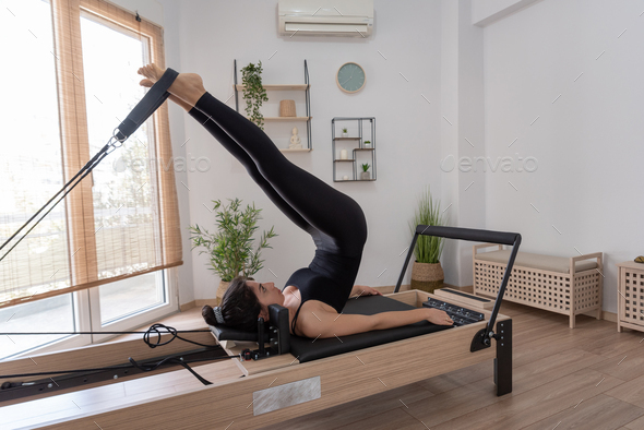 Young Woman Exercising On Pilates Reformer Bed Stock Photo By Sianstock